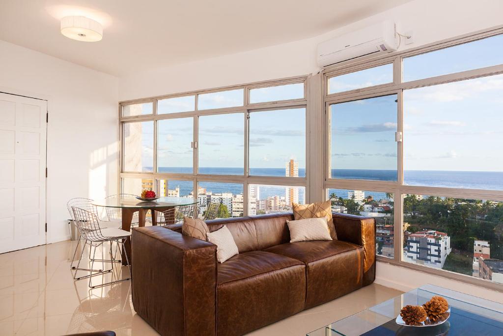 萨尔瓦多Luxury Surround Sea View Apartment的客厅配有棕色沙发和桌子
