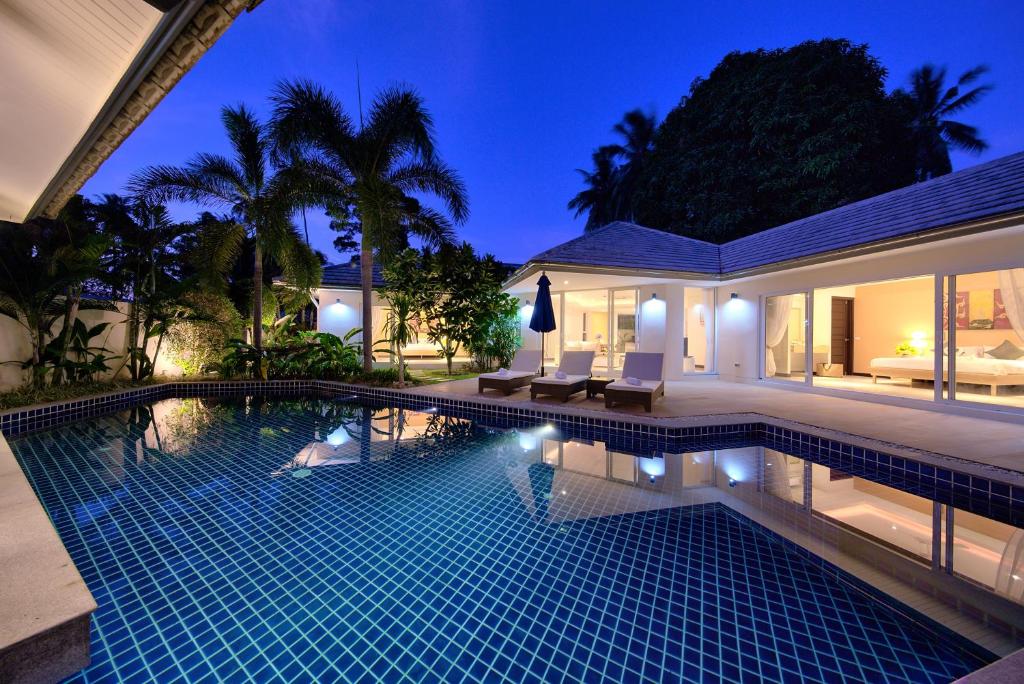 纳通市BAAN RIM TALAY - Beach Side 2 Bed Pool Villa的夜间在房子前面的游泳池