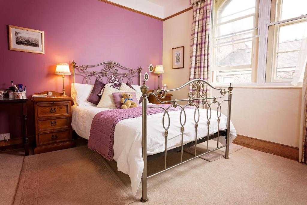 博德明Roscrea Bed & Breakfast的一间卧室配有一张紫色墙壁和窗户的床