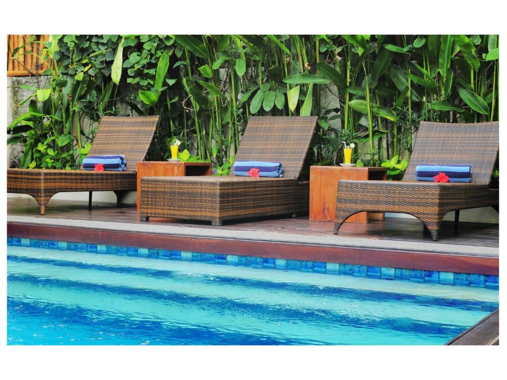 勒吉安阿拉纳套房酒店的一组长椅,坐在游泳池旁