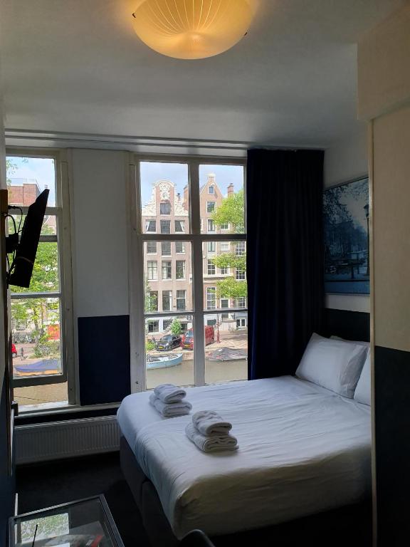 阿姆斯特丹Hotel Hoksbergen的有大窗户的房间里的一张床
