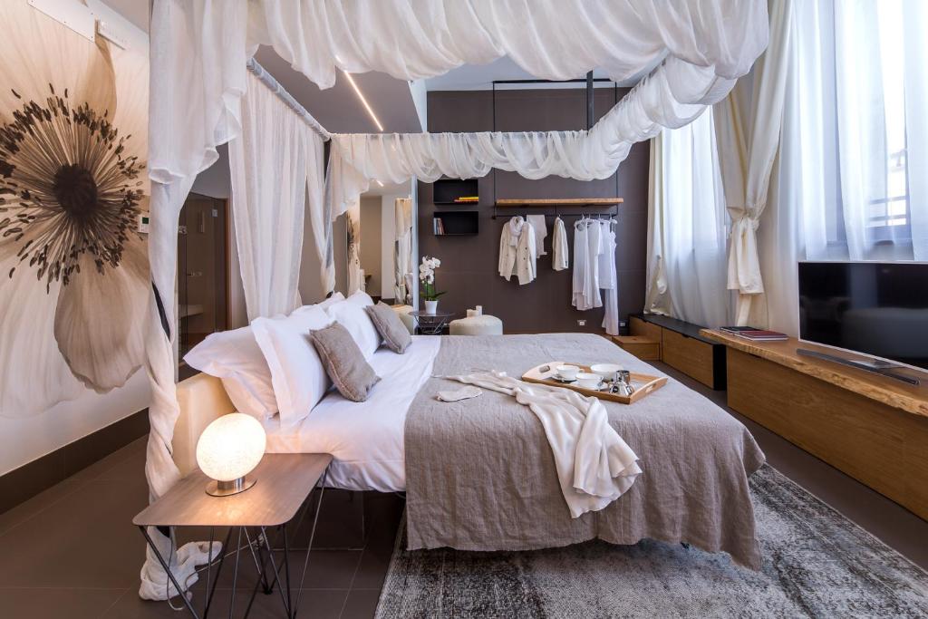 乌迪内梅卡托维奇奥豪华套房酒店的一间卧室配有一张天蓬床和一台电视机