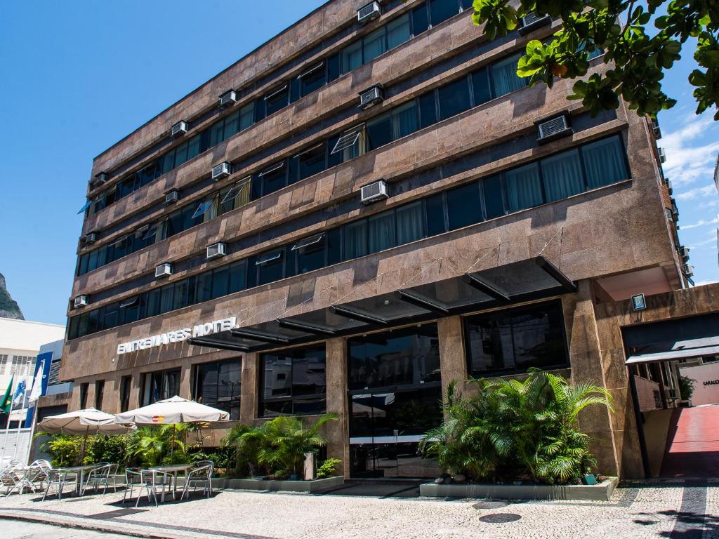 里约热内卢安特拉玛赫斯酒店的前面有桌子和伞的建筑