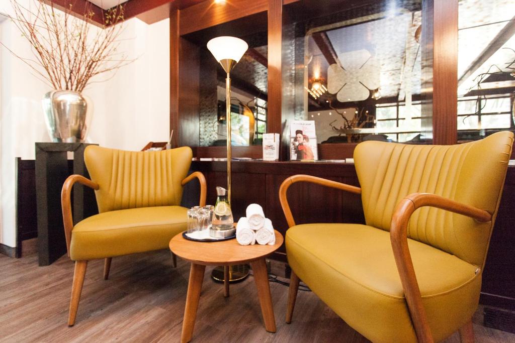 威斯巴登Trip Inn Klee am Park Wiesbaden的餐厅里两张黄色的椅子和一张桌子