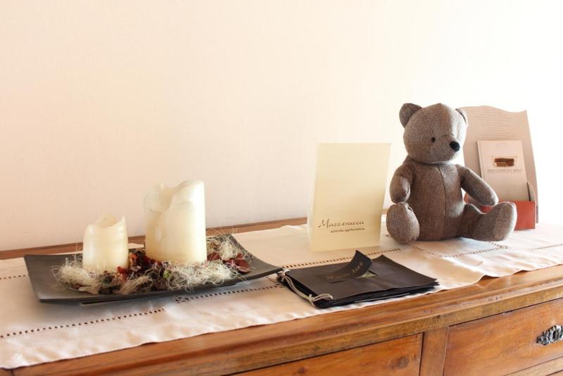 巴萨诺－德尔格拉帕Agriturismo Mazzeracca的一只泰迪熊坐在一张带蜡烛的桌子上
