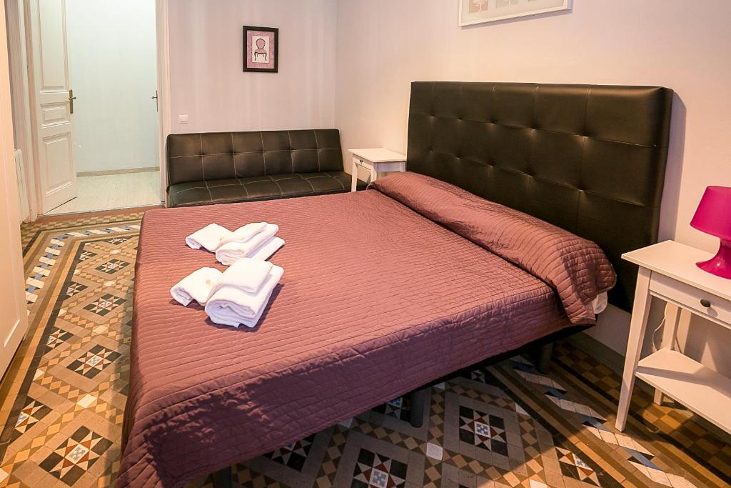 巴塞罗那巴尔姆斯中央旅馆的一间卧室配有一张床,上面有两条毛巾