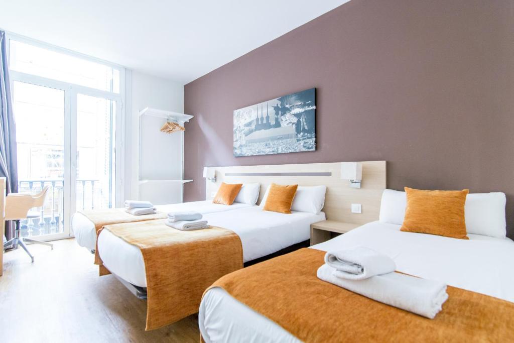 巴塞罗那巴塞罗那中心酒店的酒店客房设有两张床和一张桌子。