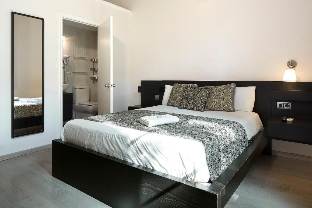 巴塞罗那BruStar Gotic-Centric的一间带黑色和白色床的卧室以及一间浴室。
