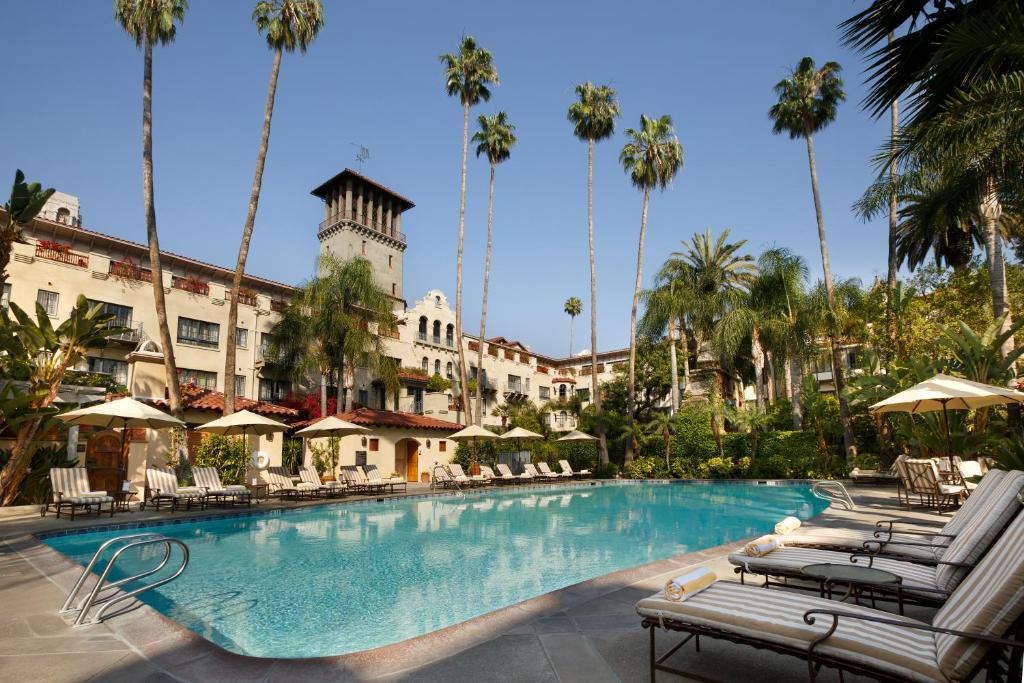 里弗赛德米申Spa酒店的一座游泳池,里面摆放着椅子和棕榈树