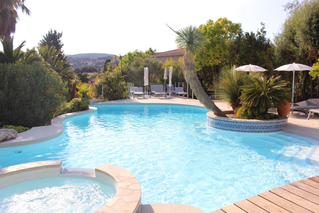 卡西斯皇家小别墅酒店的一个带棕榈树和遮阳伞的大型游泳池