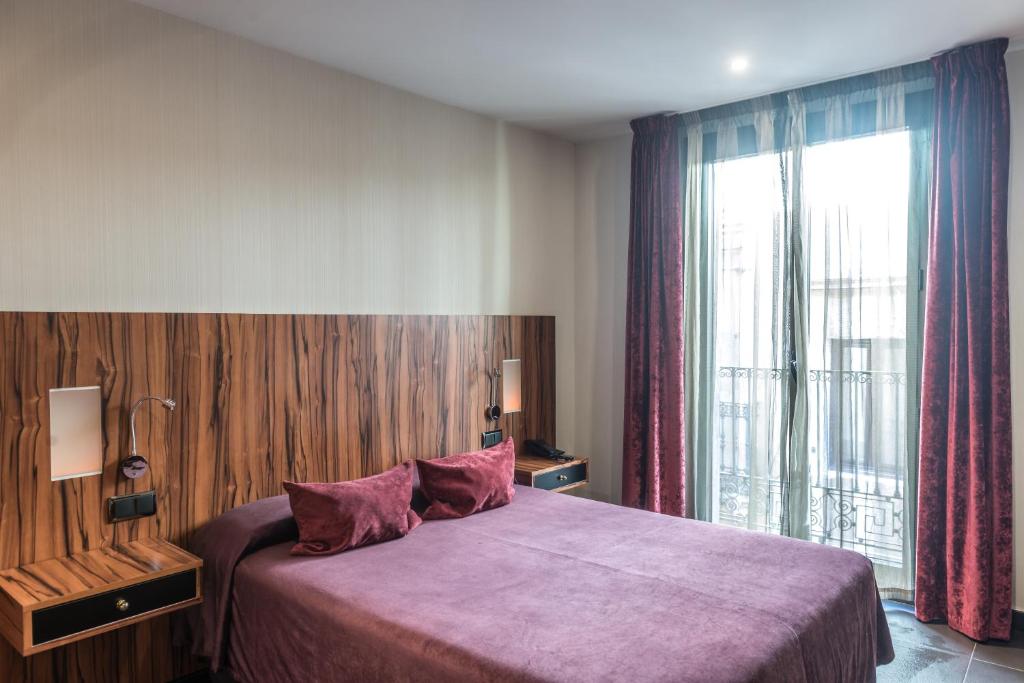 巴塞罗那加州酒店的一间卧室设有一张大床和一个大窗户