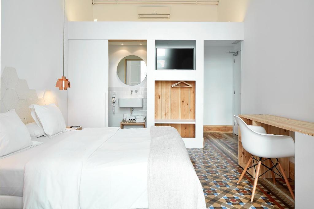 巴塞罗那安东尼精品旅馆的卧室配有一张白色大床和一张书桌