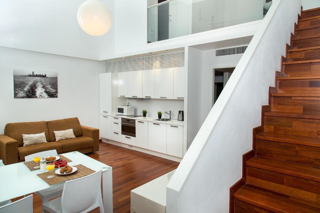 巴塞罗那Glasir Apartments Barcelona的一间厨房和客厅,客厅设有楼梯。