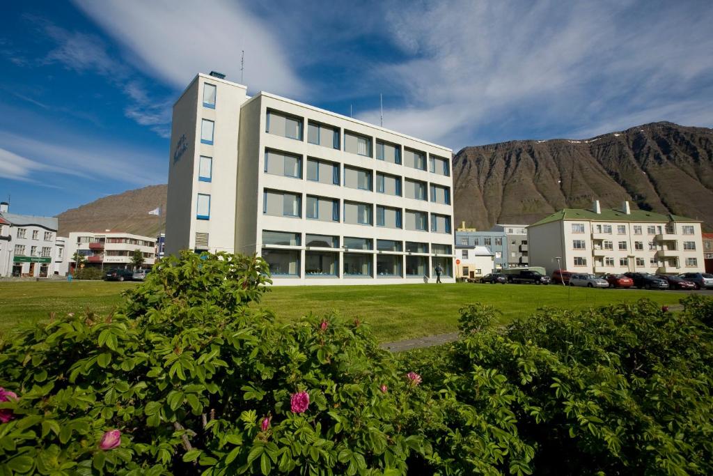 伊萨菲尔德Hotel Isafjördur - Torg的一座白色的大建筑,背景是一座山