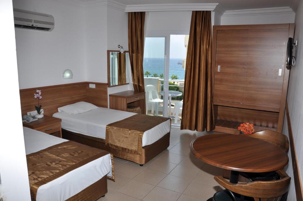 阿拉尼亚Kleopatra Tuna Apart Hotel的酒店客房设有两张床和一张桌子。