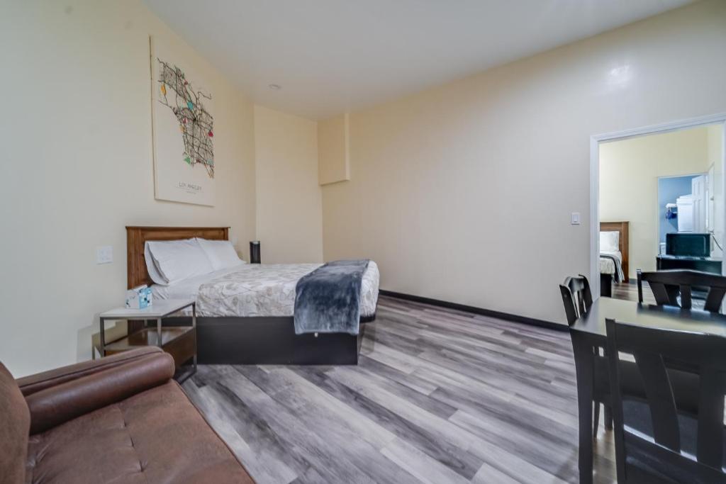 洛杉矶24 Hours Motel的一间带床和客厅的酒店房间
