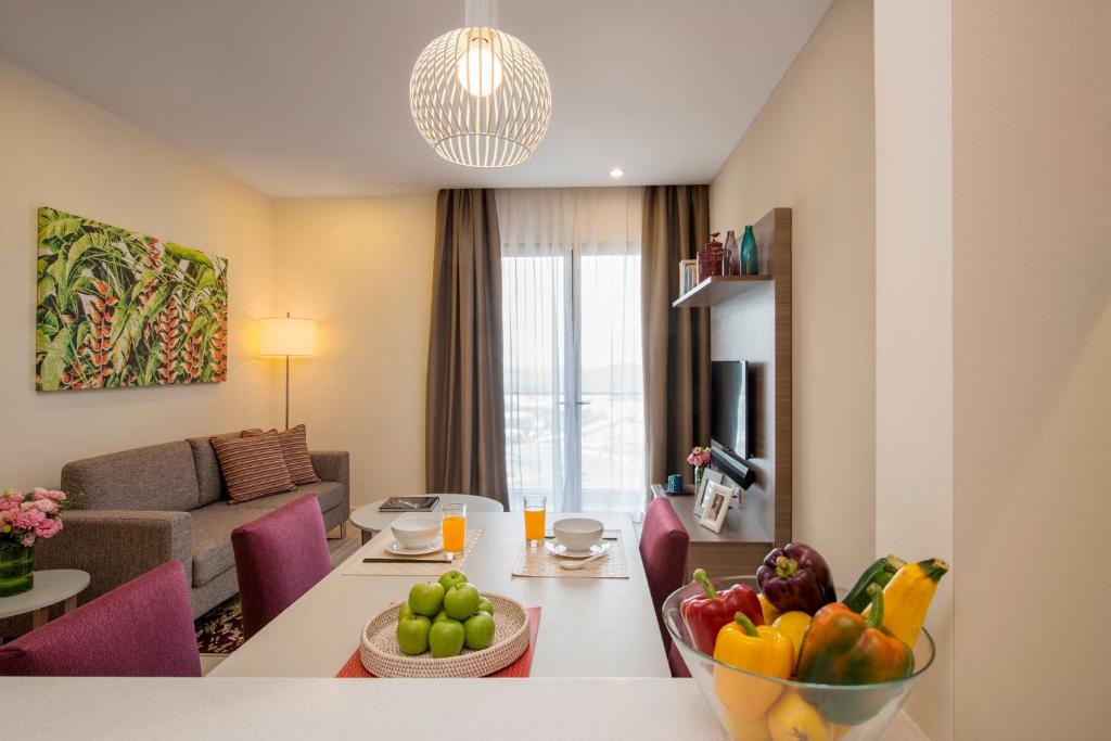 努沙再也萨默塞特梅迪尼斯卡达尔公寓的客厅配有带一碗水果的桌子