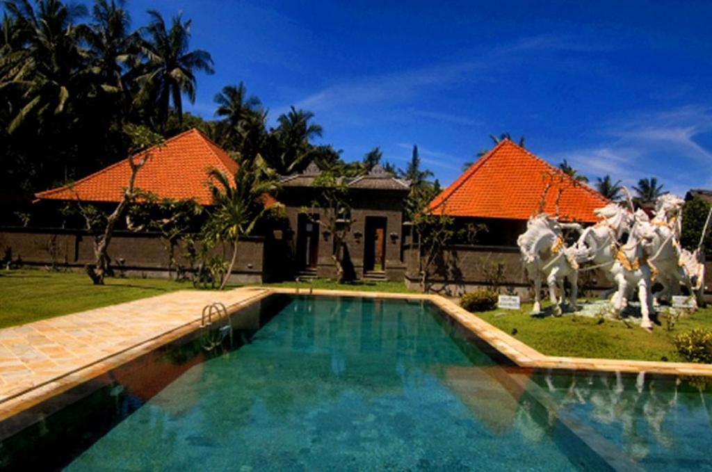 八丹拜普里清莱酒店的一座房子,拥有一个带马雕像的游泳池