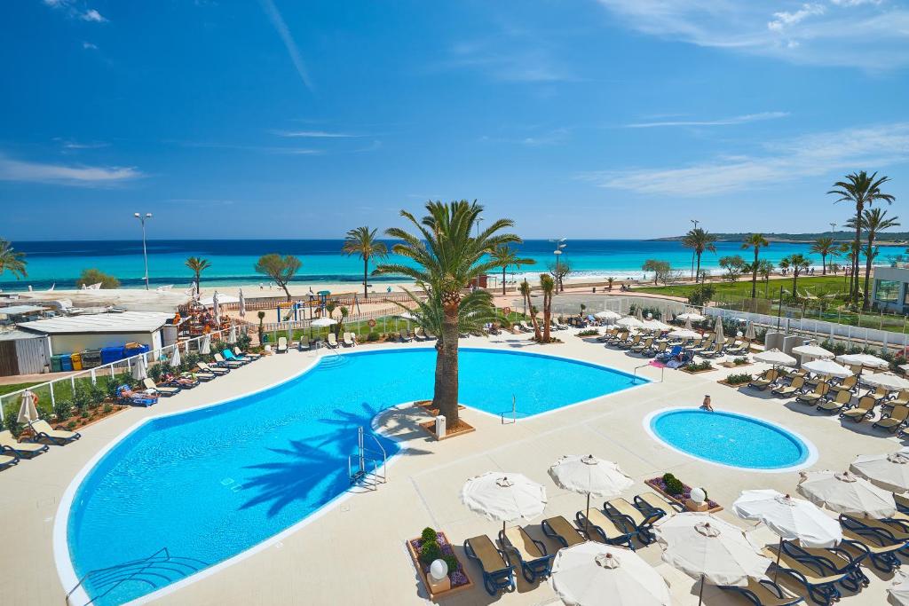 卡拉米洛梅萨德斯时尚酒店公寓的享有游泳池和海滩的上方景色,配有椅子和遮阳伞