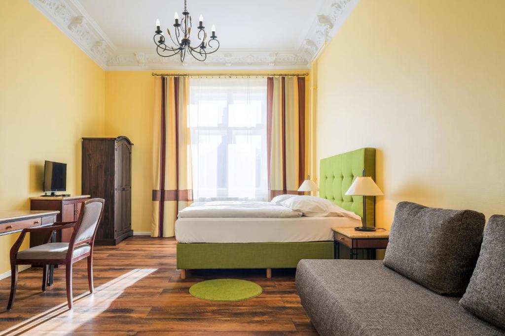 柏林米歇尔酒店的一间卧室配有一张床、一张桌子和一张沙发