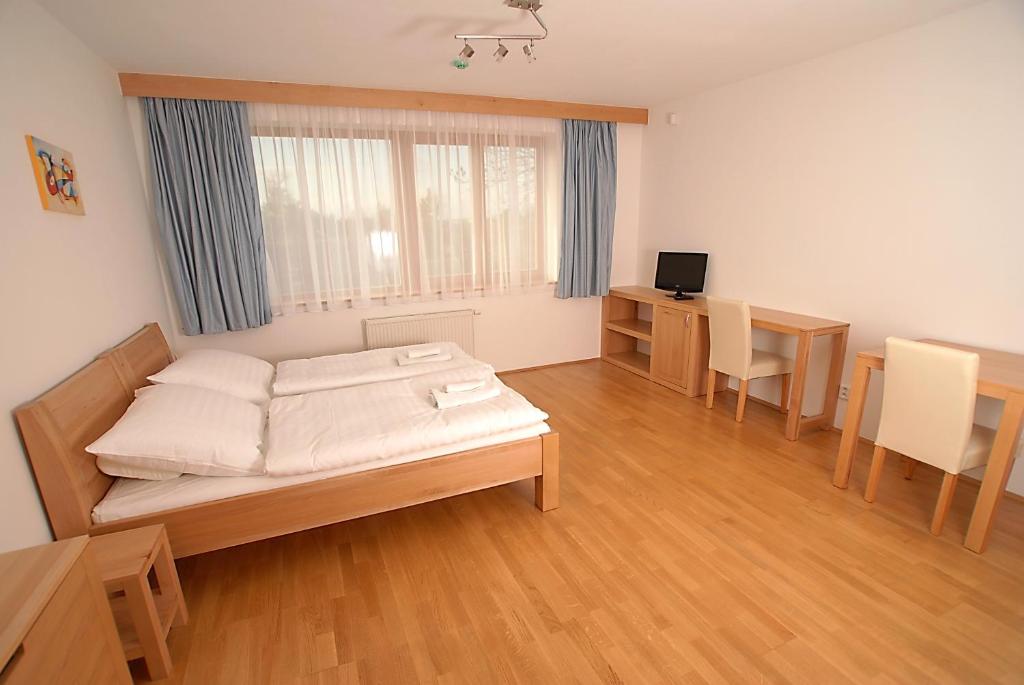 布拉格布拉托夫公寓及健康酒店的客房设有一张床、一张桌子和一张书桌。
