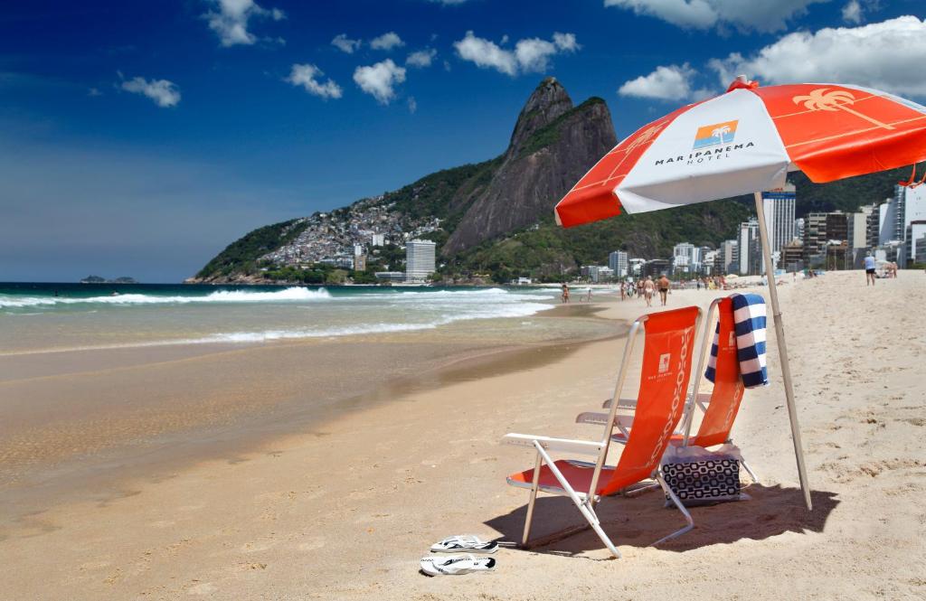 里约热内卢玛因帕纳玛酒店的一个带两把椅子和一把遮阳伞的海滩
