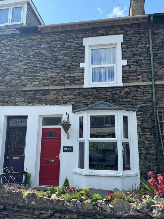 温德米尔Ramblers Retreat Windermere的红门和窗户的砖房