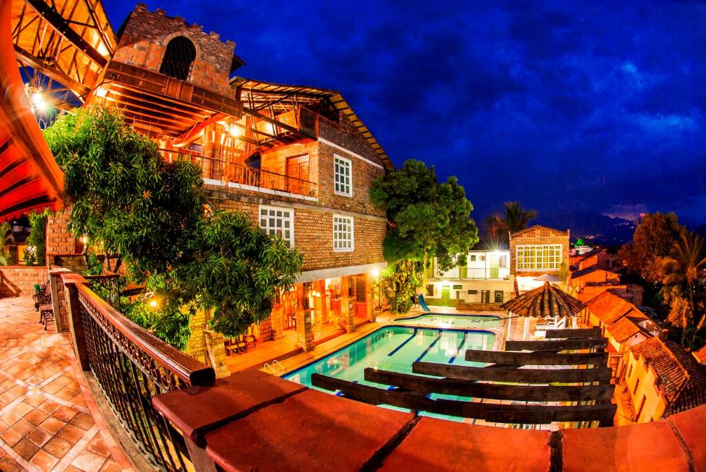 圣菲德安蒂奥基亚Hosteria de la Plaza Menor的一座游泳池,在晚上在建筑物前