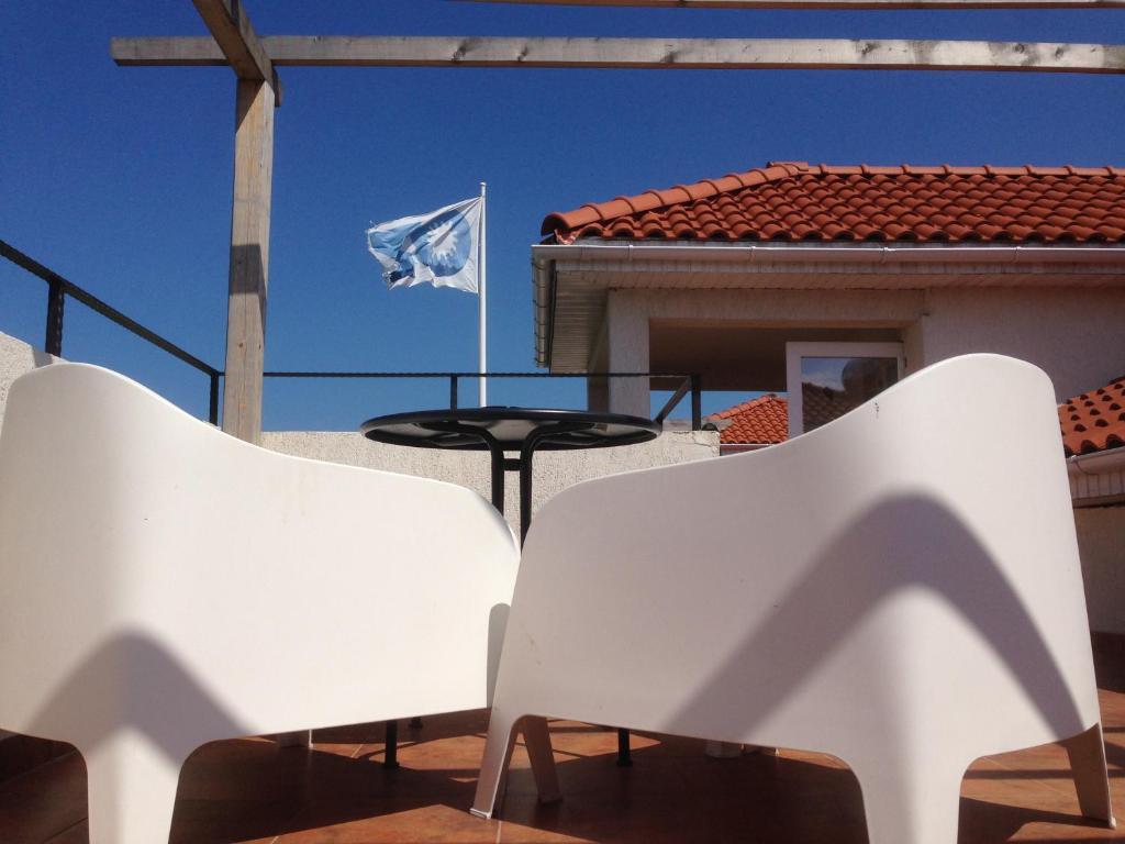 旧瓦马OZ Vama Veche的庭院里一对白色椅子和一面旗帜