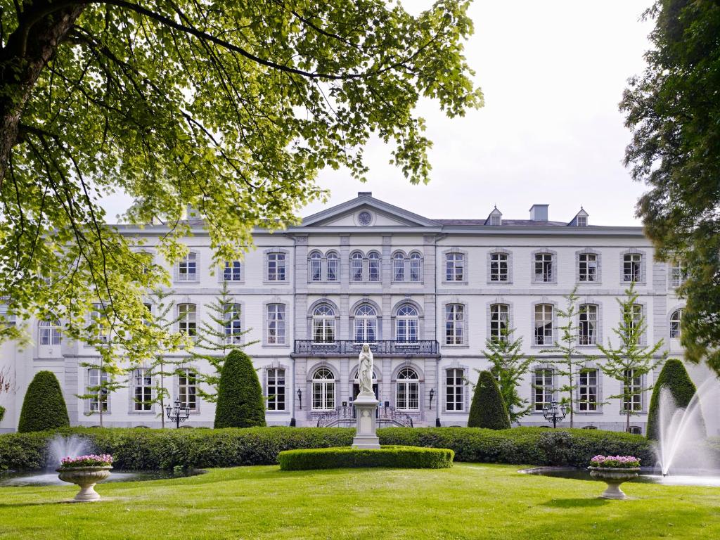 瓦尔斯凡德瓦克酒店的一座大型白色建筑,在庭院里设有一个喷泉