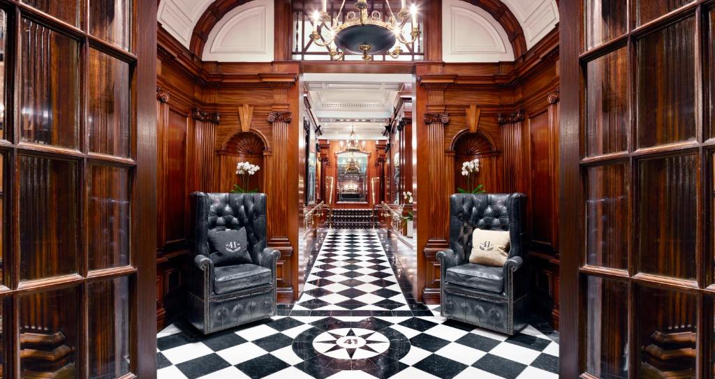 伦敦红色康乃馨41酒店的走廊上设有两把椅子和一格棋盘地板