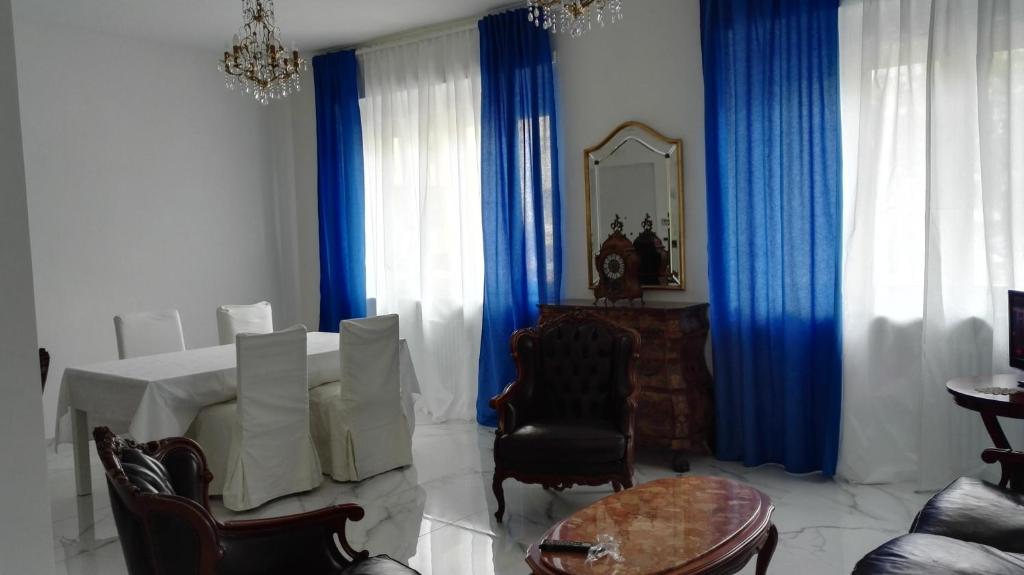 都灵卡萨妮萨住宿加早餐旅馆的客厅配有桌子和蓝色窗帘