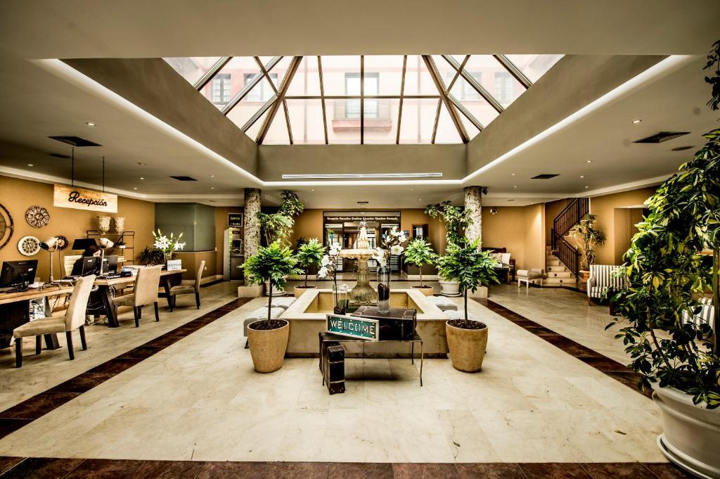 洛杉矶德圣拉斐尔塞戈维亚瓜达拉马山脉酒店的大堂设有盆栽和桌椅