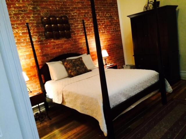 帕迪尤卡The 1857的一间卧室设有一张床和砖墙