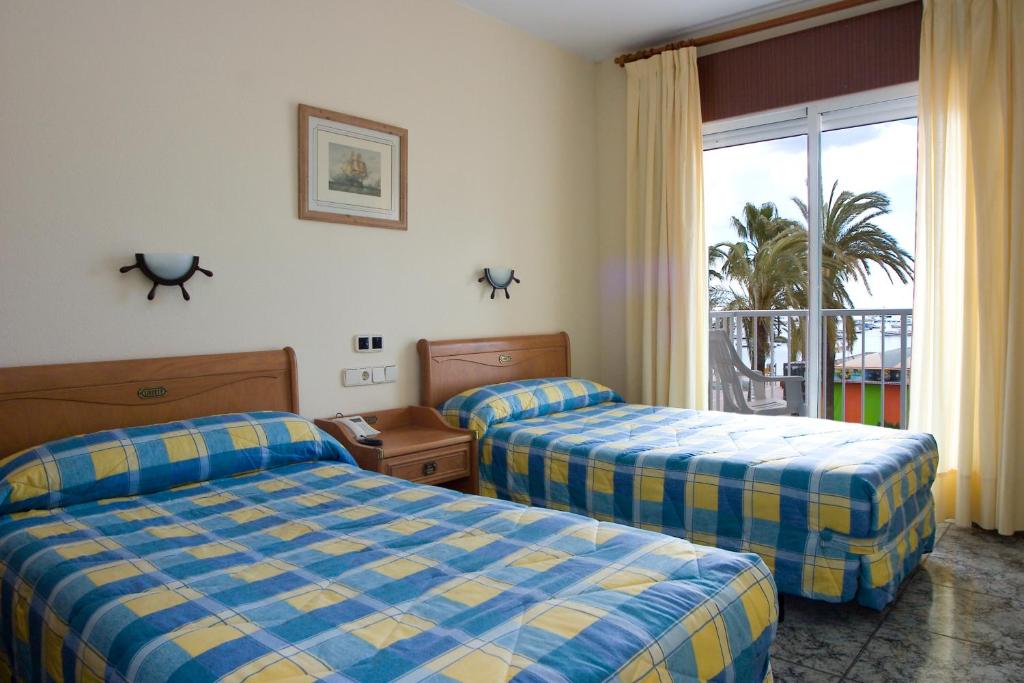 圣地亚哥德拉里贝拉萨尔瓦多圣马力诺酒店的酒店客房设有两张床和一个阳台。