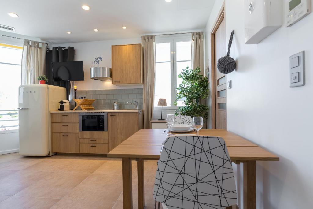 滨海卡涅圣皮埃尔宫公寓的厨房配有木桌和冰箱。