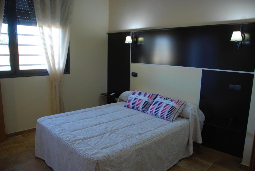 代米耶尔Casa Rural Virgen de las Cruces的一间卧室配有一张带黑色床头板的床