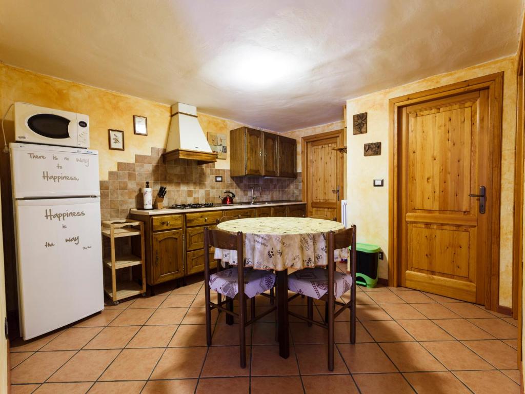 普拉吉拉托Appartamento Dal Maestro Serafino的厨房配有桌子和冰箱