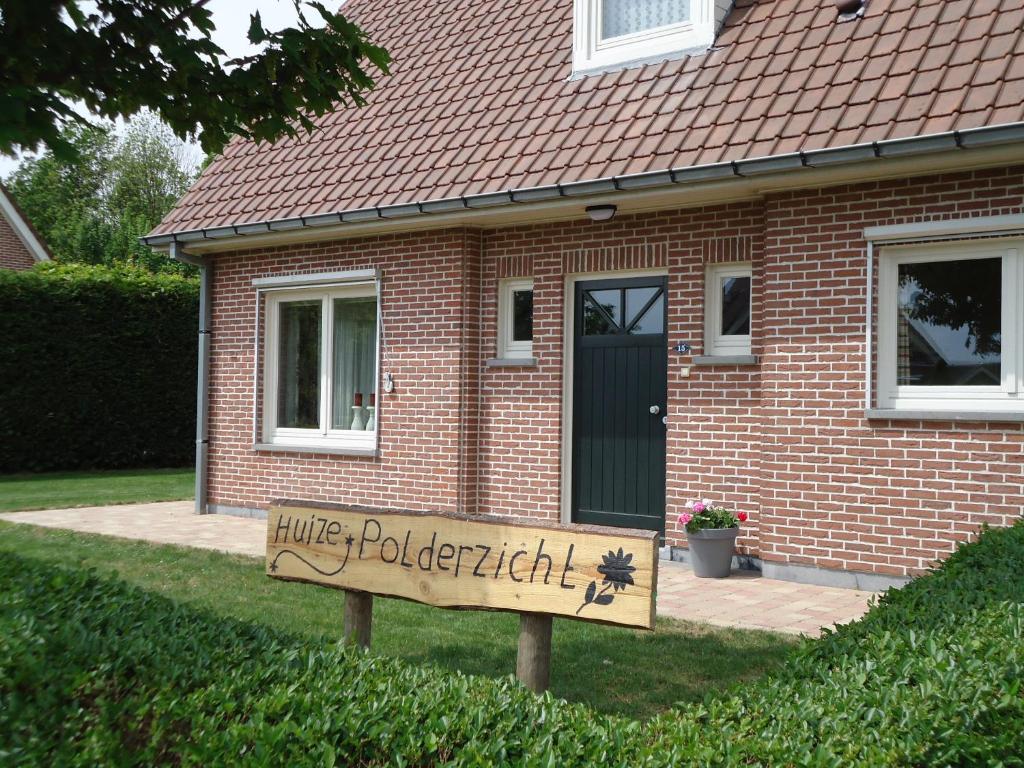 BattenoordHuize Polderzicht aan het Grevelingenmeer的房屋前有标志的房子