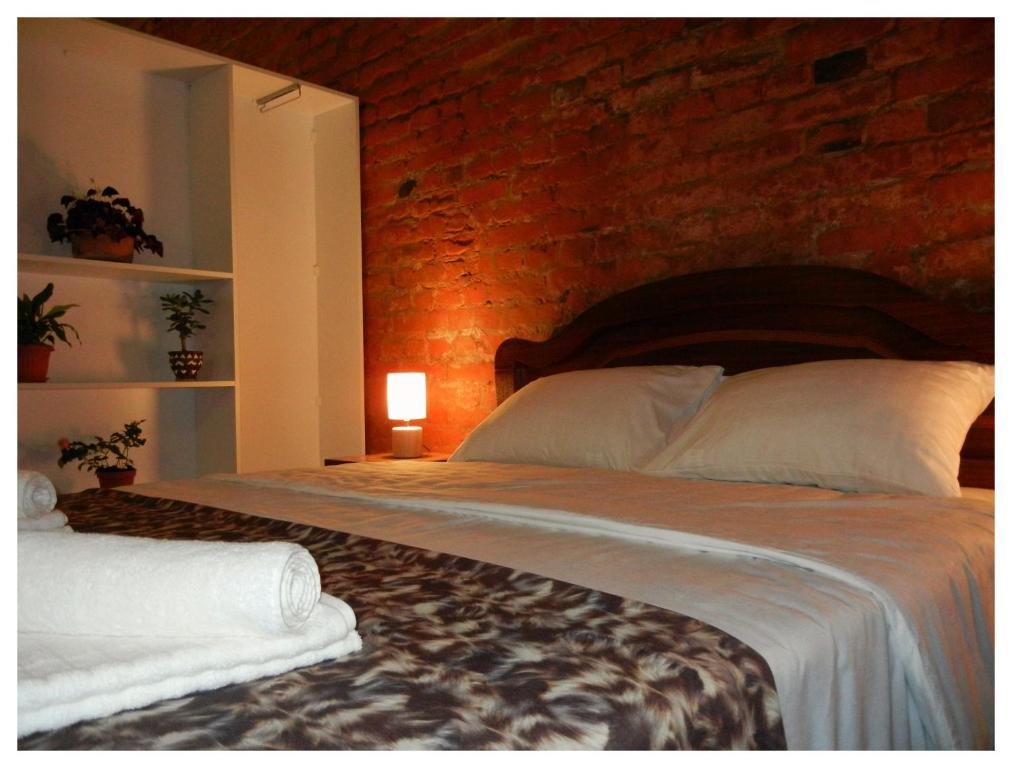 第比利斯Tbilisi Apartment的一间卧室设有一张带砖墙的大床