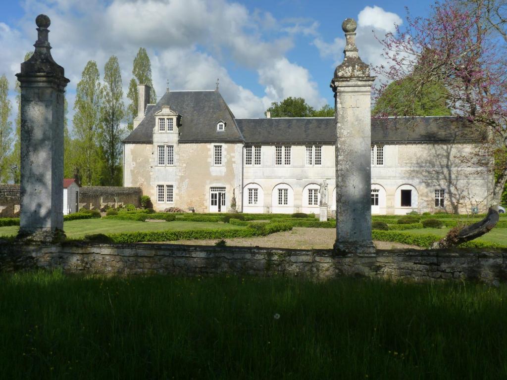 BignouxLOGIS du Château du Bois Doucet的一座白色的大房子,前面有石墙