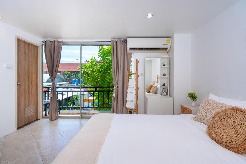 卡塔海滩Kata Station Boutique Hotel的一间带白色床的卧室和一个阳台