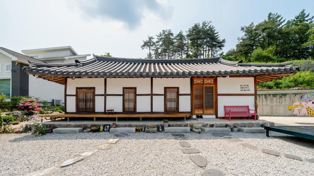 江陵市Gangneung ggabinejip hanok pension的院子里有一座亚洲式屋顶的小房子