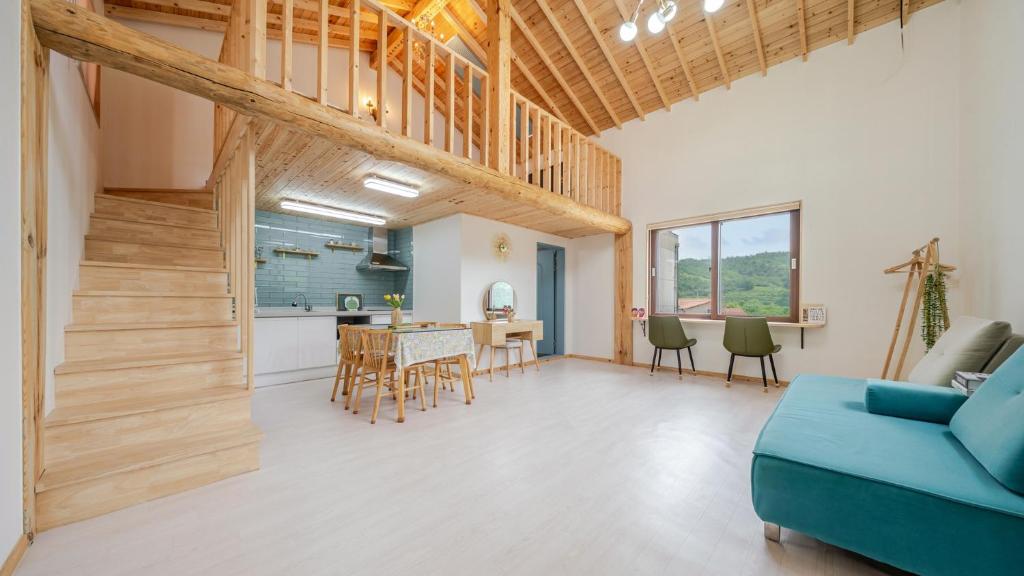 江陵市Gangneung ggabinejip hanok pension的带蓝色沙发的客厅和厨房
