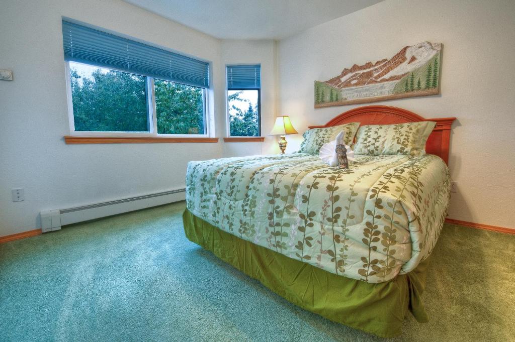 朱诺Frontier Suites Hotel in Juneau的一间卧室设有一张床和两个窗户。
