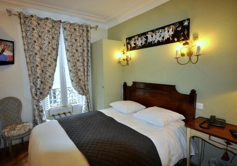 巴黎德班酒店的一间卧室配有一张床、一张书桌和一个窗户。