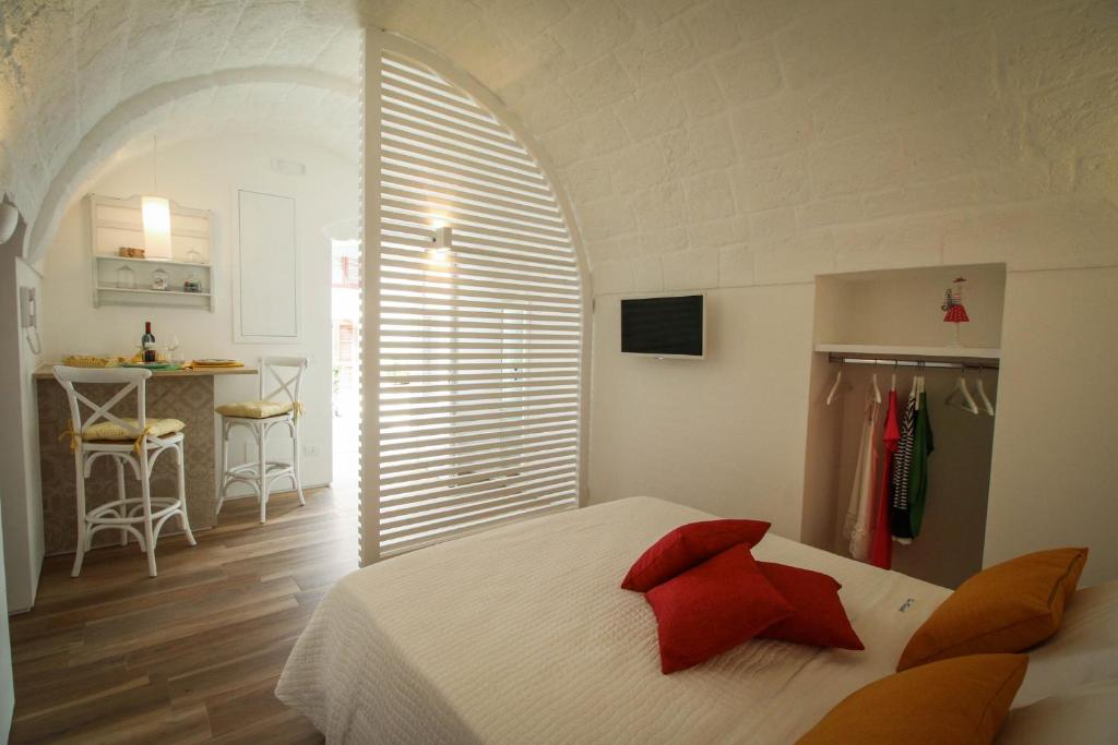 莫诺波利马里斯特拉度假屋的卧室配有带红色枕头的白色床