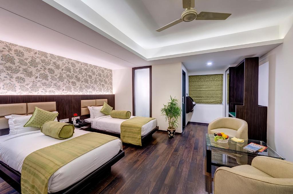 加尔各答总督精品酒店的酒店客房设有两张床和一张桌子。