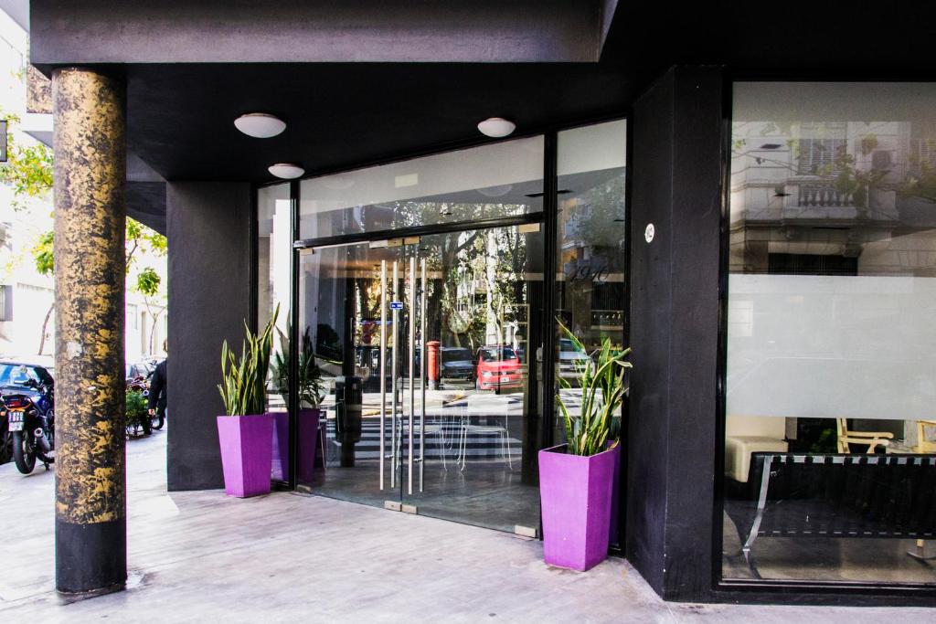 布宜诺斯艾利斯Épico Recoleta Hotel的商店前方有粉红色的盆,里面有植物