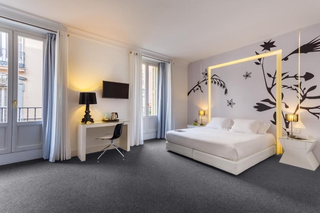 马德里马里奥室友酒店的卧室配有白色的床和树壁画